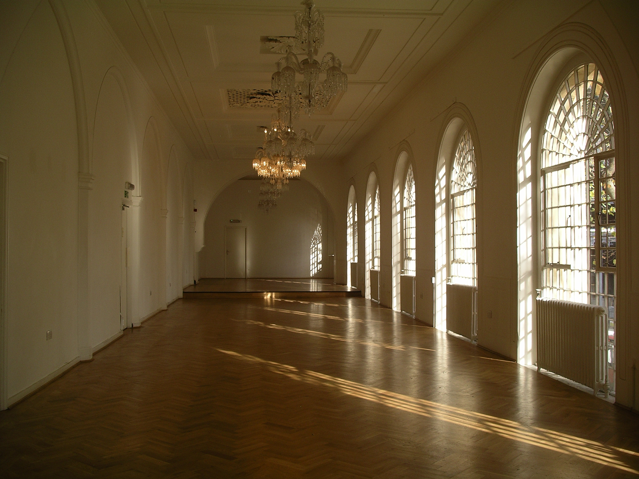 Elegant event space at One Marylebone with arched windows and chandeliers.