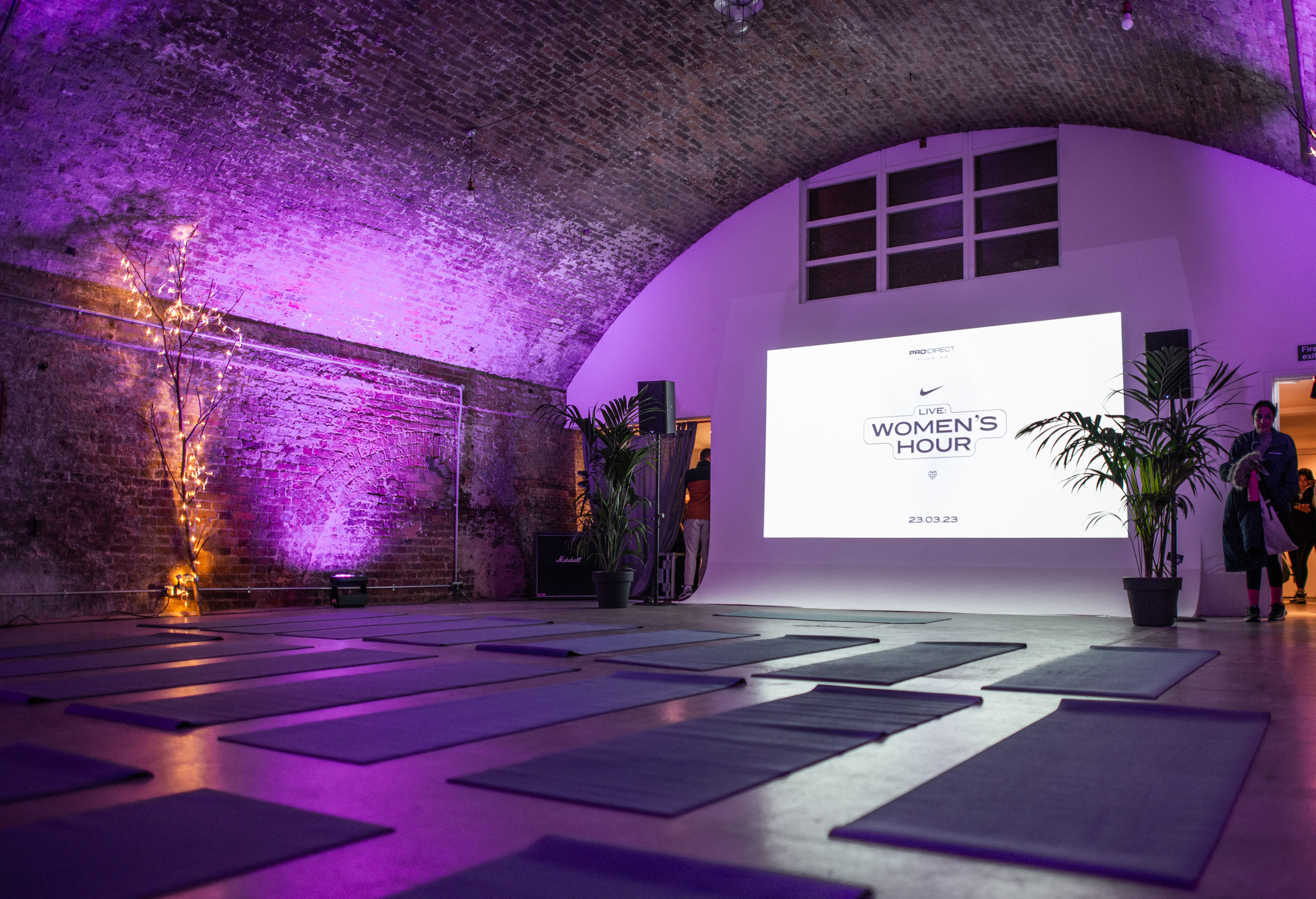 Stylish wellness event space with yoga mats and calming purple lighting in MOTEL.