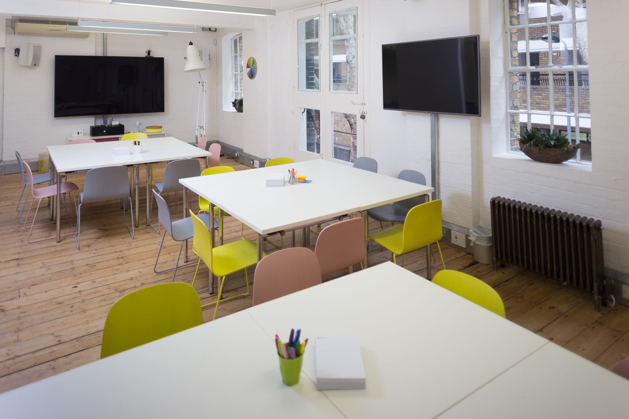 Versatile meeting space with colorful chairs, ideal for workshops and brainstorming sessions.