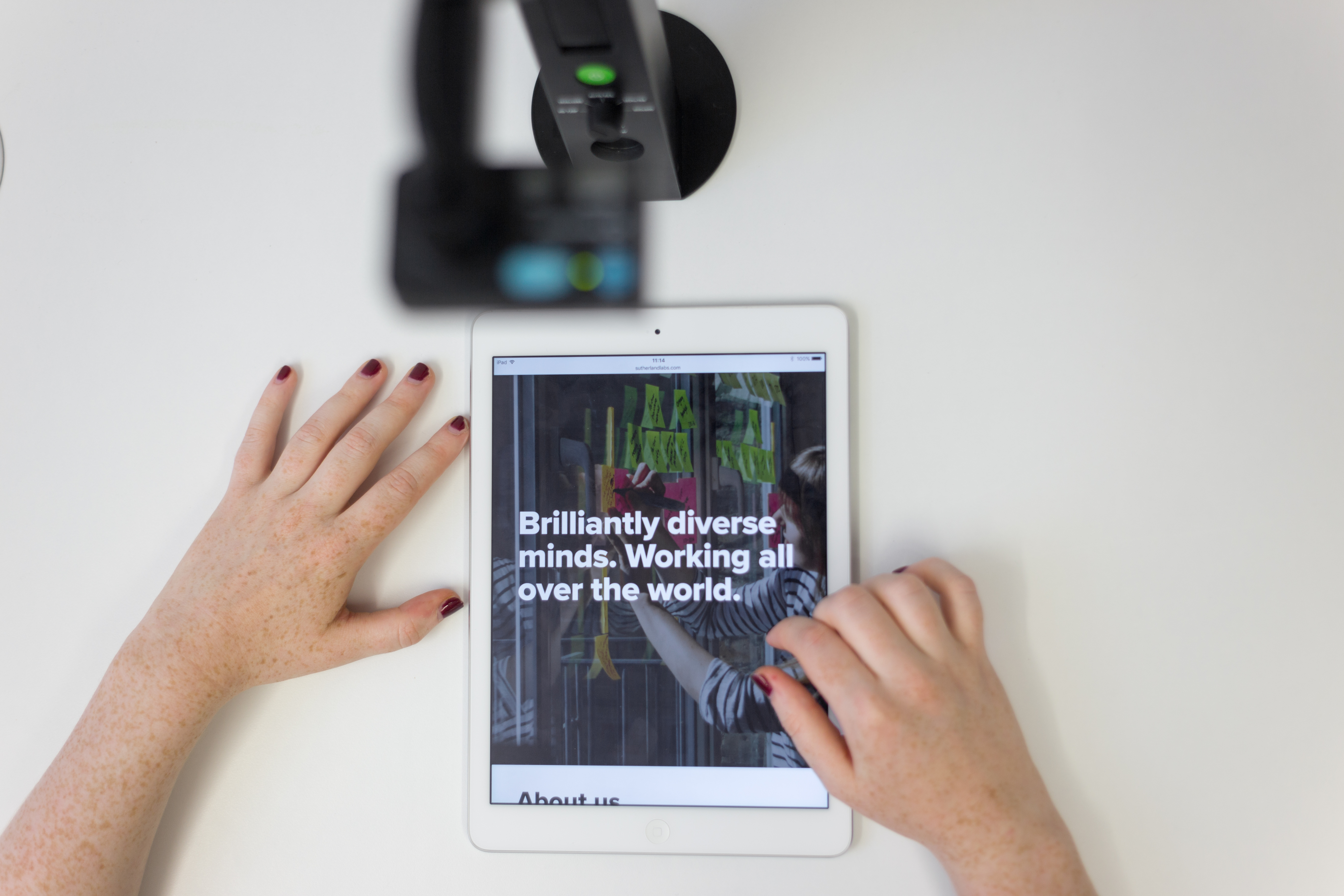 Hybrid event planning setup with tablet showcasing interactive presentations in Sutherland Labs.
