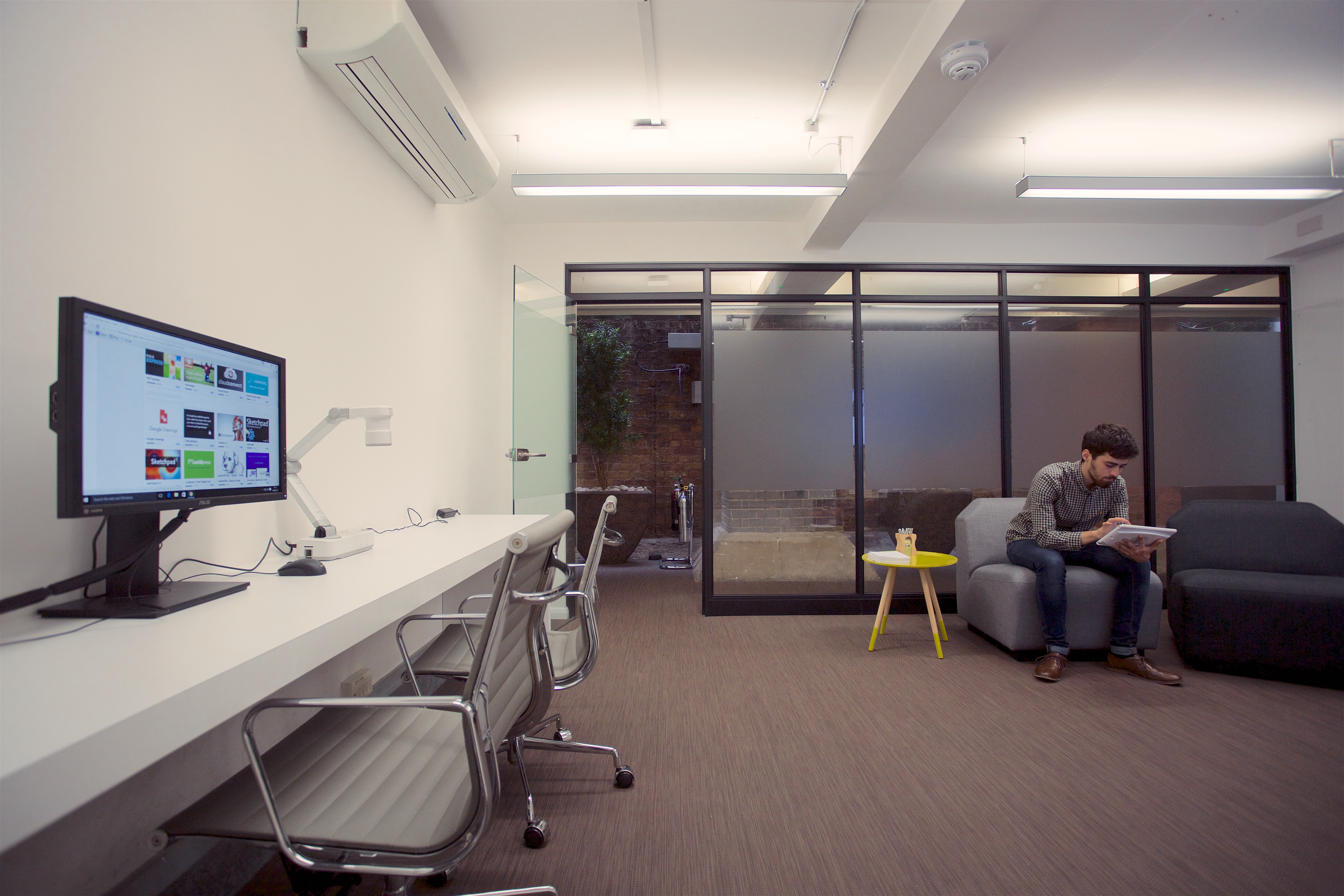 Modern meeting space in Sutherland Labs, featuring sleek desk and cozy seating for collaboration.