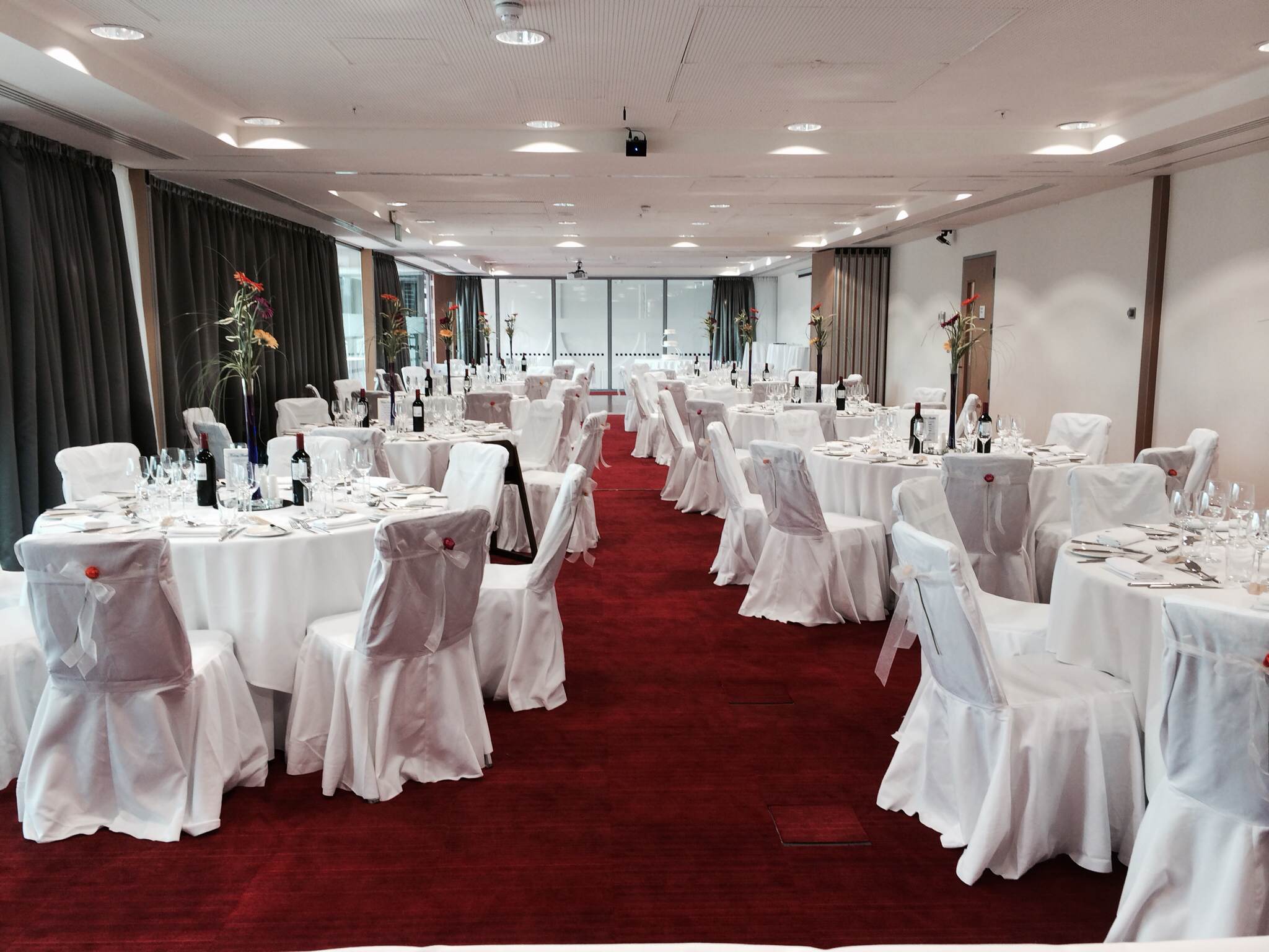 Elegant event space with tables dressed in white linens for corporate gatherings.