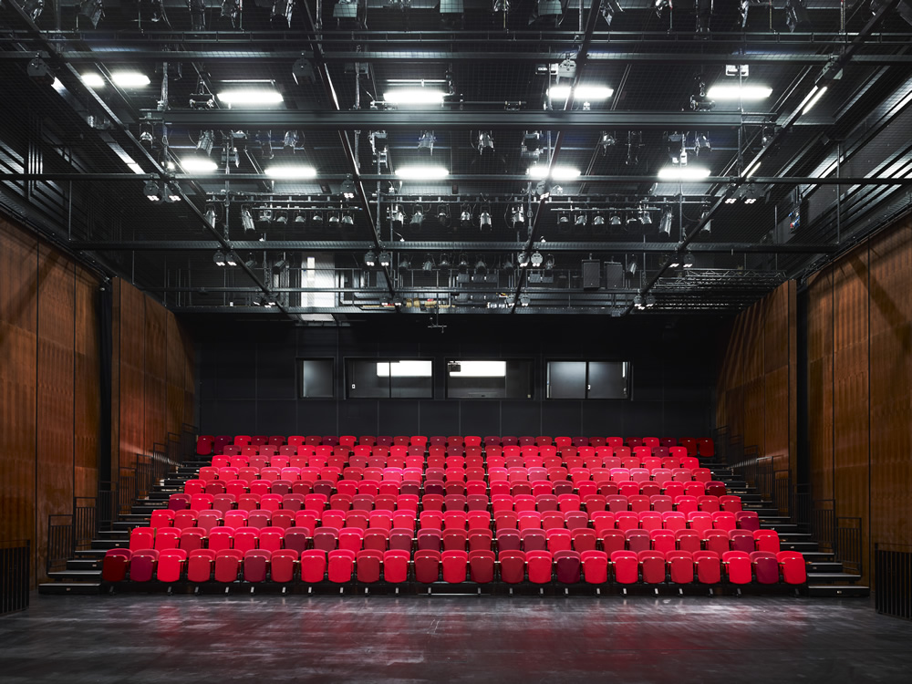 Spacious theater with tiered red seating for impactful presentations and performances
