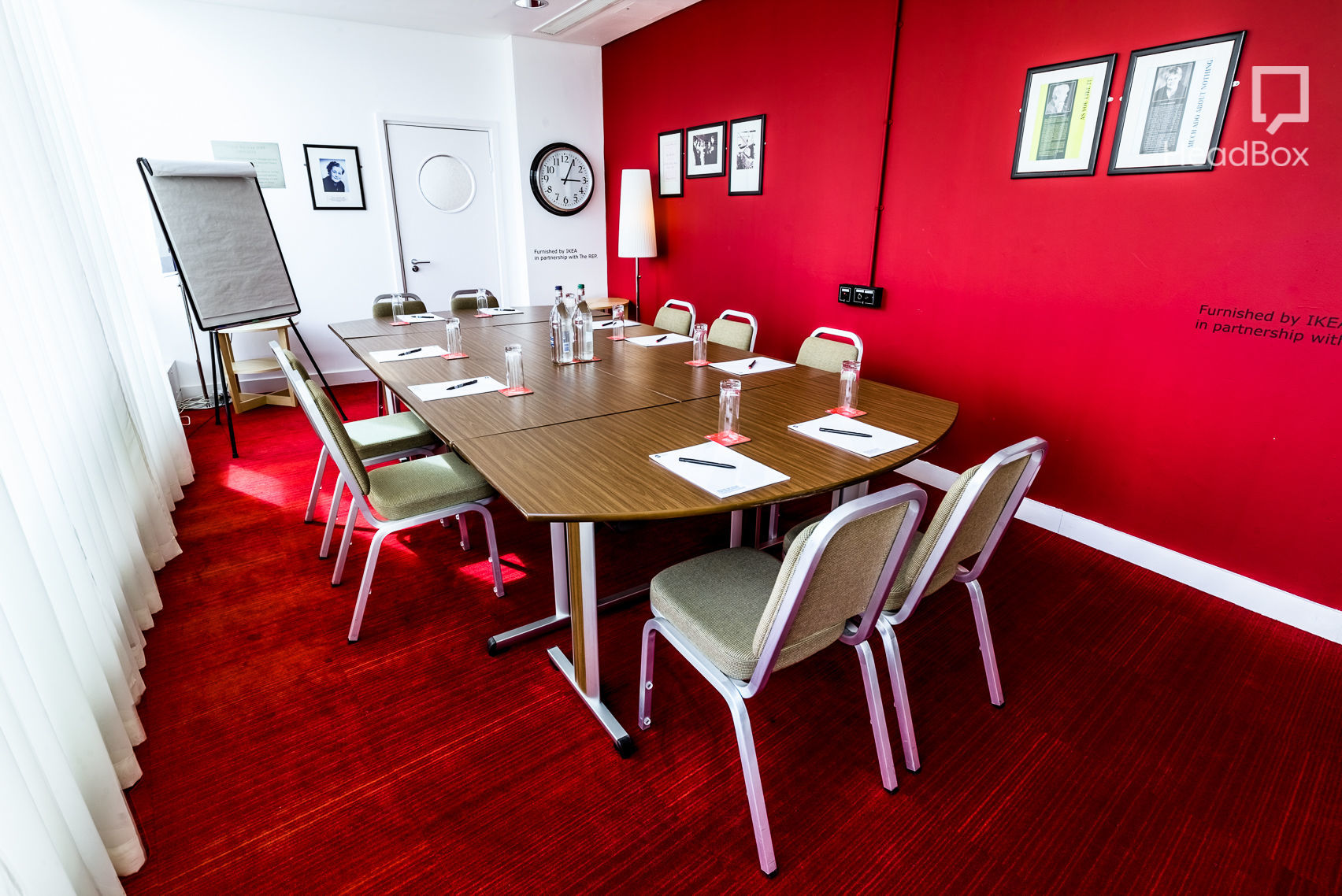 Modern meeting room at Unique Venues Birmingham with vibrant red wall, ideal for conferences.