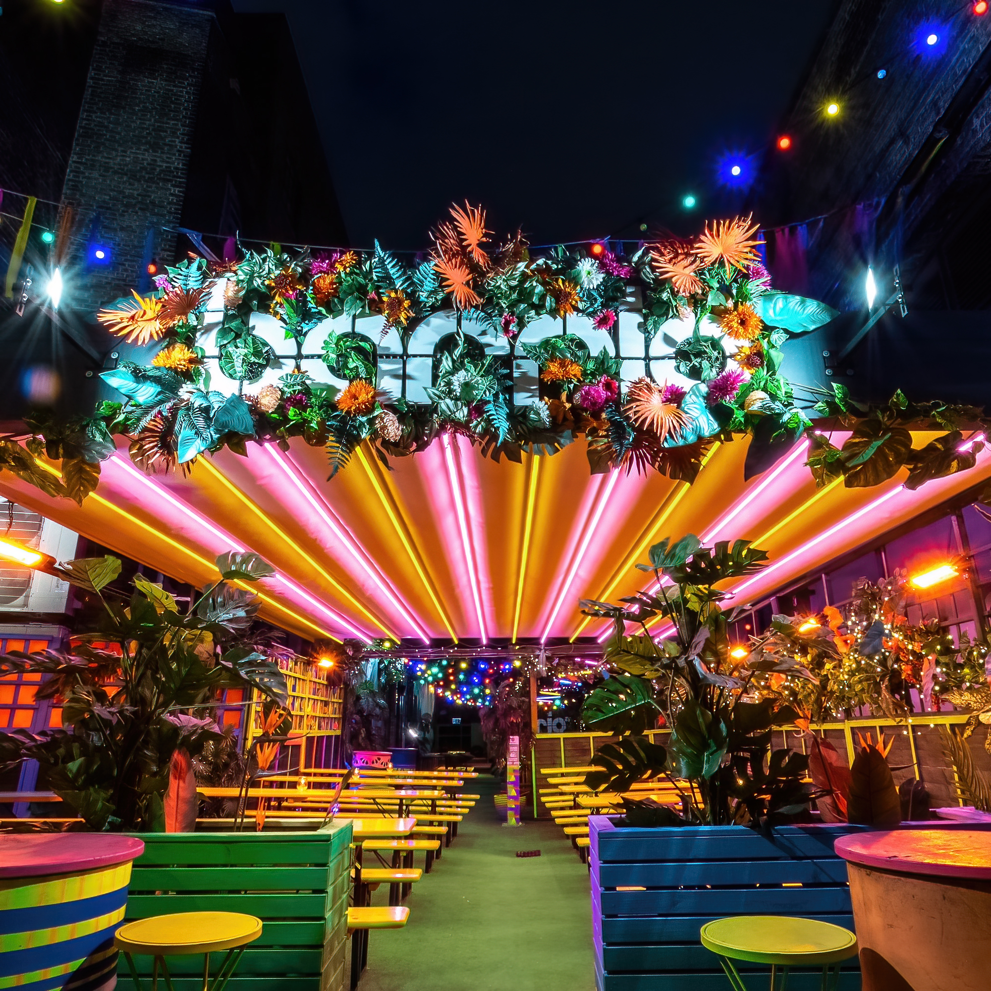 Vibrant La Terraza event space in Shoreditch with colorful floral decor and dynamic lighting.