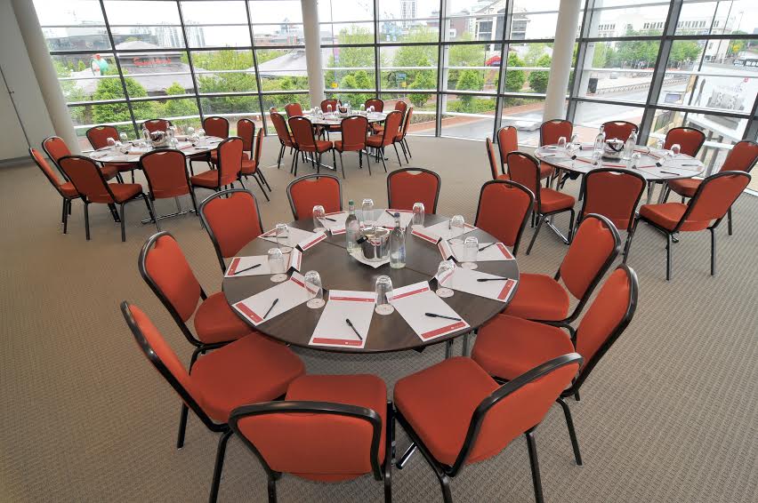 Meeting space in AC Hotel Manchester with round tables for workshops and conferences.