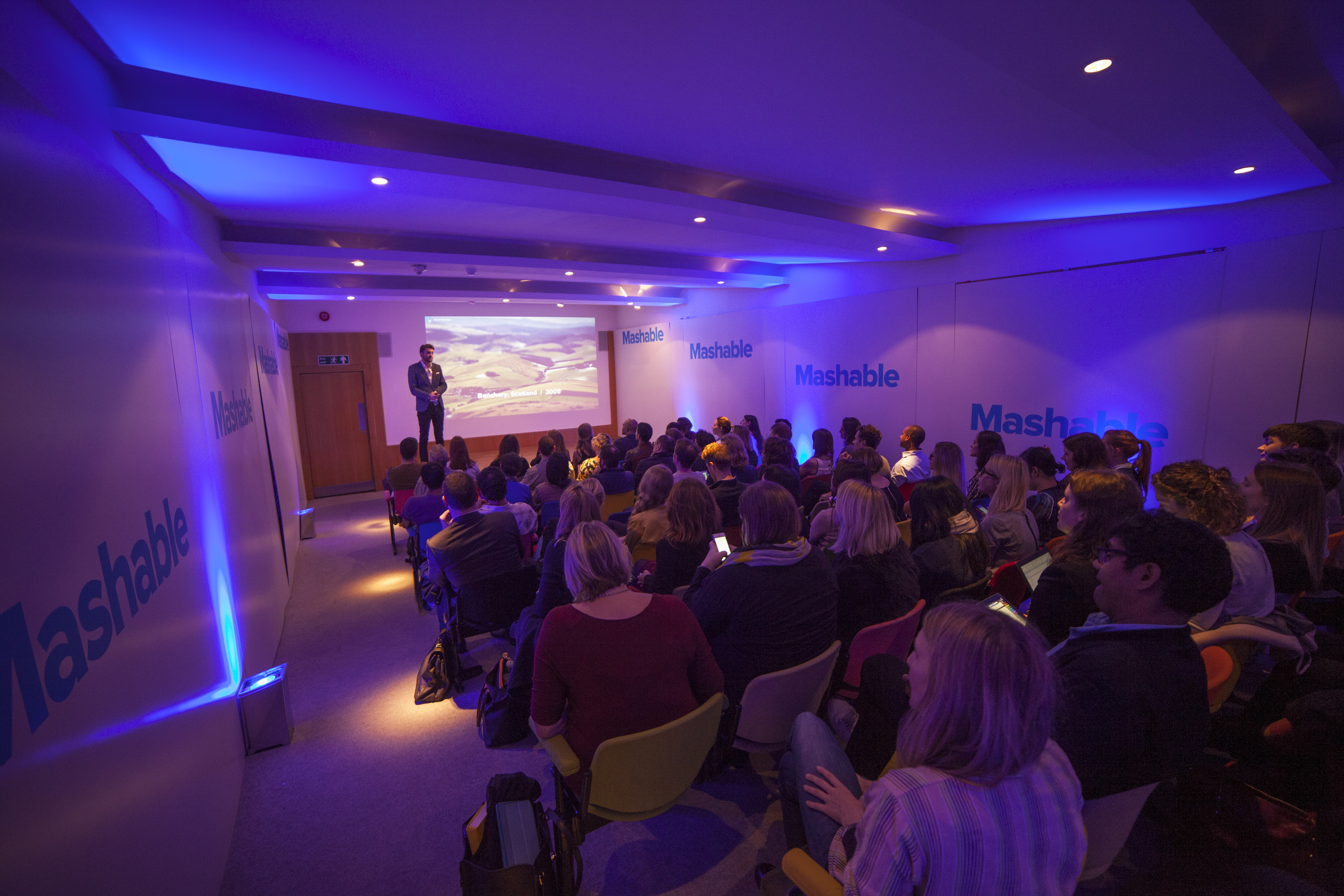 Zilkha Auditorium with blue lighting, ideal for corporate events and workshops.