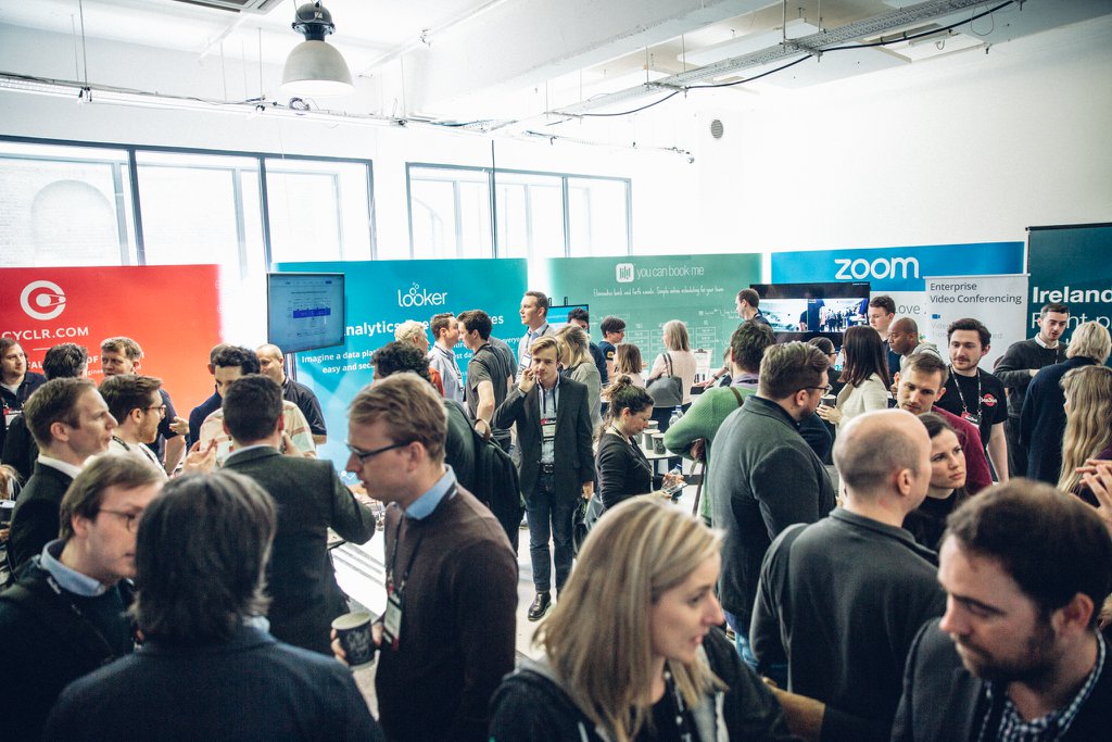 Networking event at Studio Spaces with vibrant sponsor displays and diverse attendees.