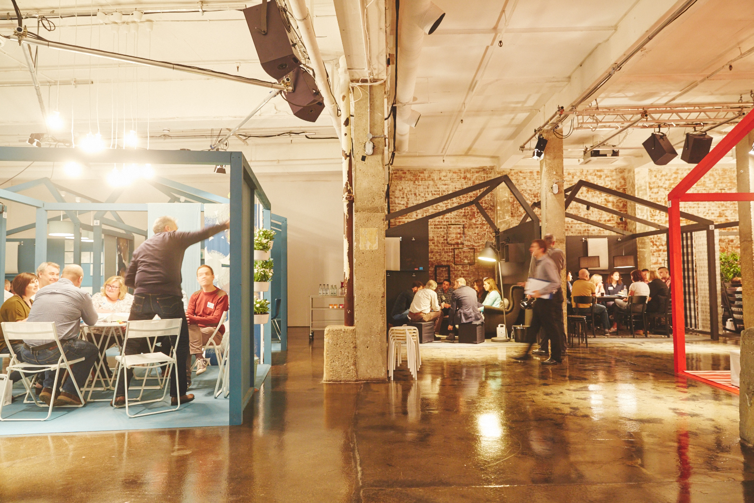 Versatile event space with colorful structures for meetings and social interactions.