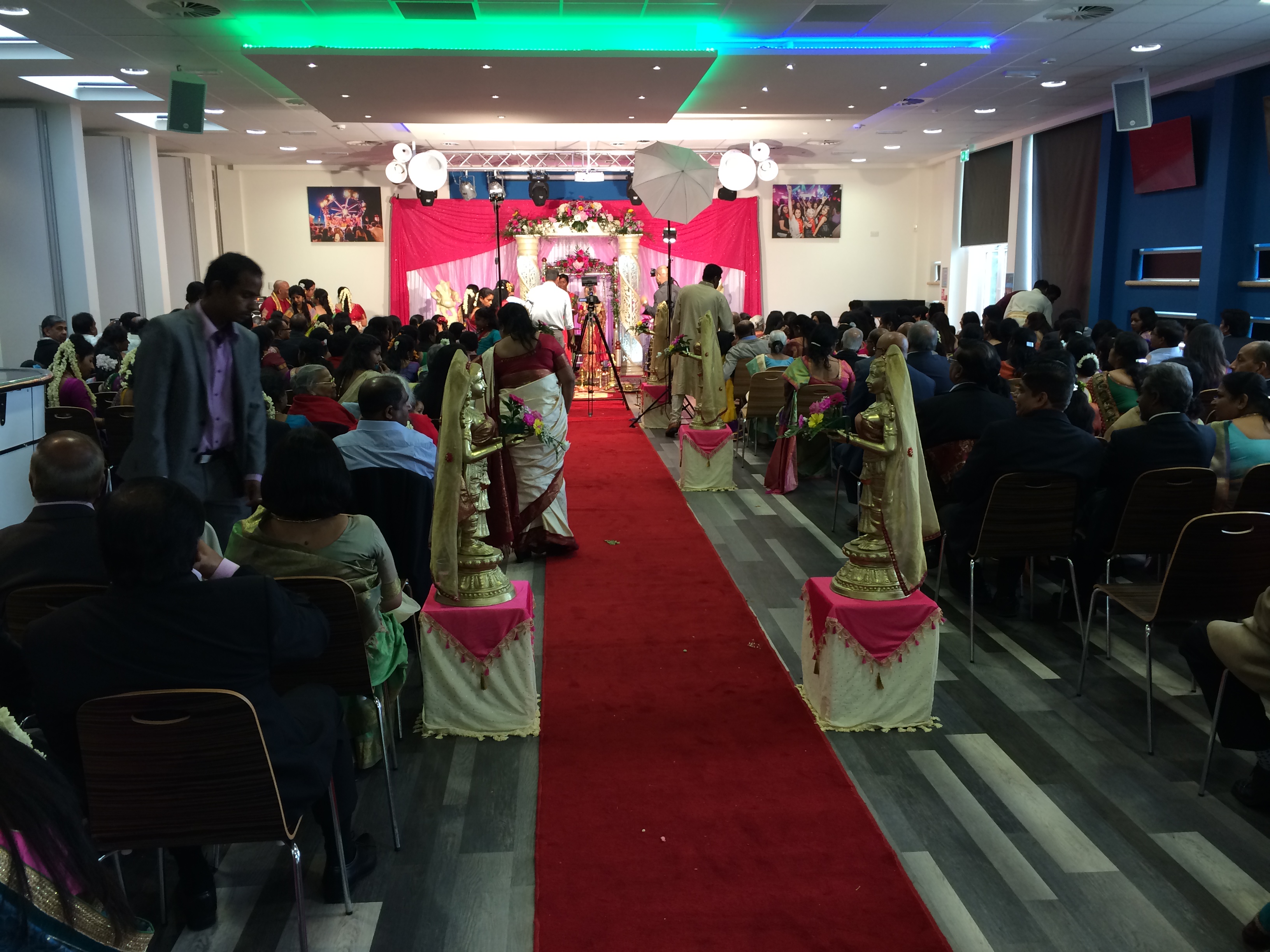 Wedding ceremony setup at Reading University with red carpet and floral decor.