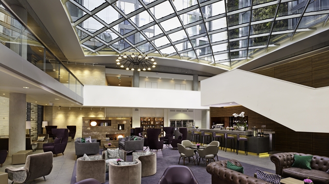 Modern lobby with glass ceiling at DoubleTree by Hilton, ideal for networking events.