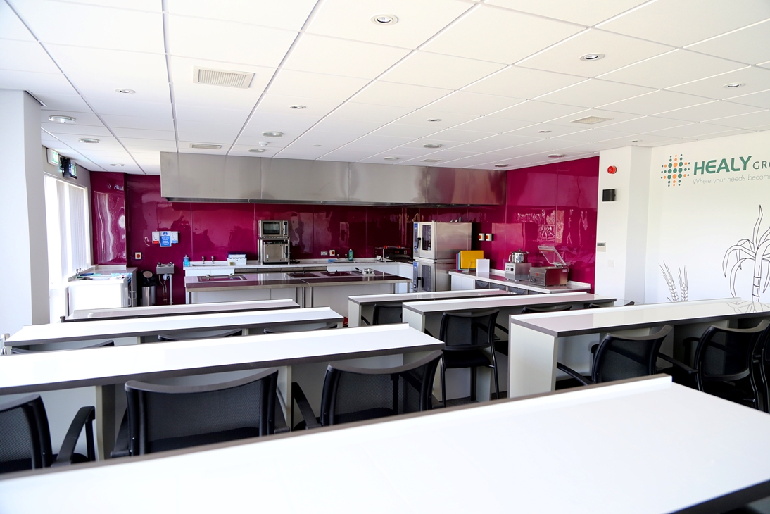 Modern kitchen with pink accent wall for culinary events and workshops.