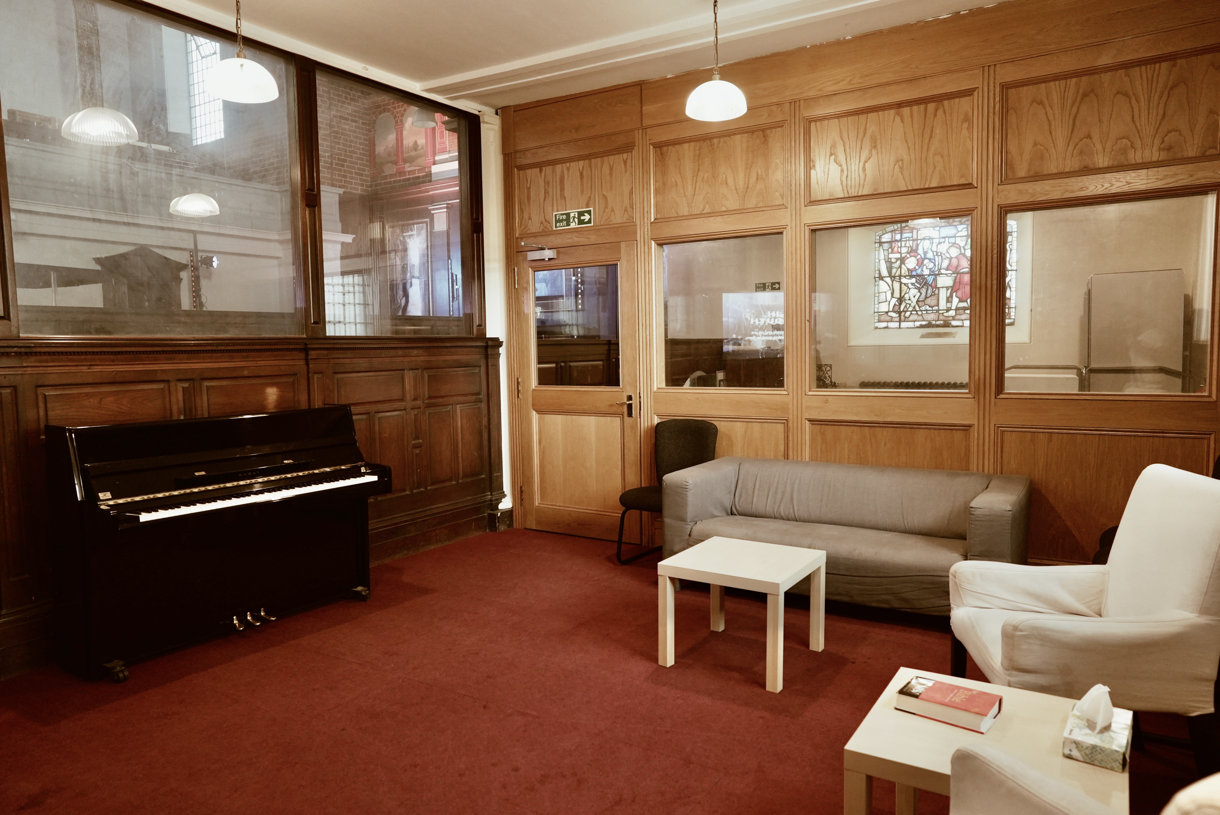 Cozy meeting space in Main Church, St John's Hoxton with black piano for networking events.