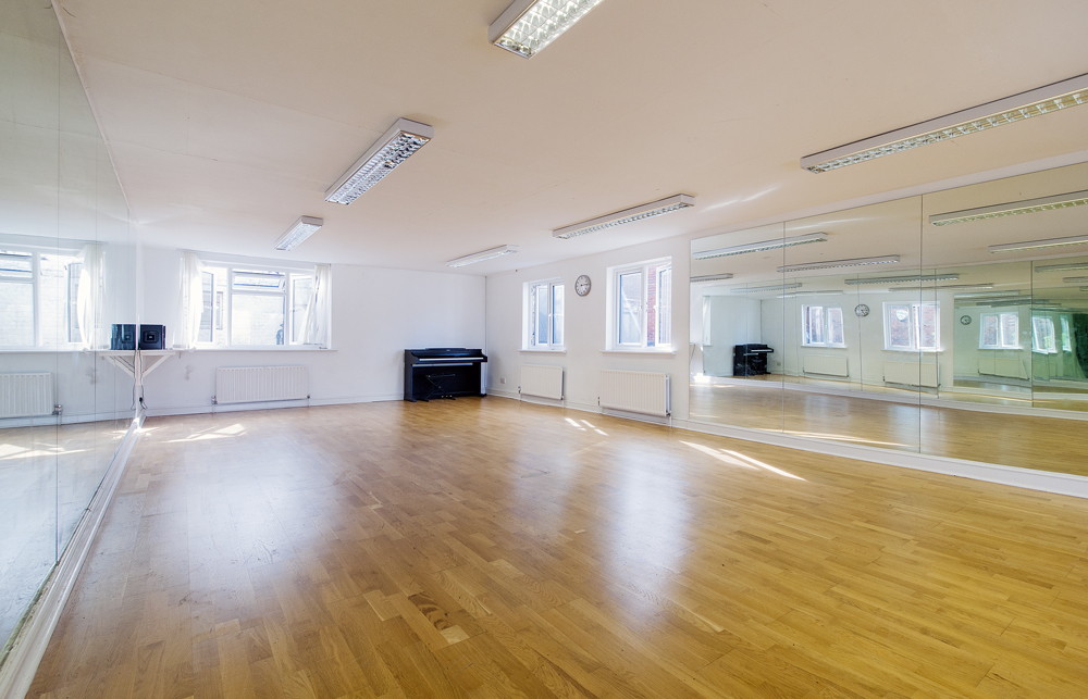 Versatile event space with polished wooden floor, ideal for workshops and dance classes.