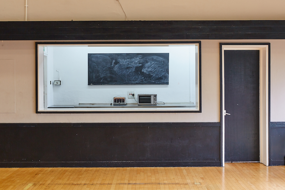 Minimalist meeting space in Mill Co. Rose Lipman with large window, ideal for workshops.