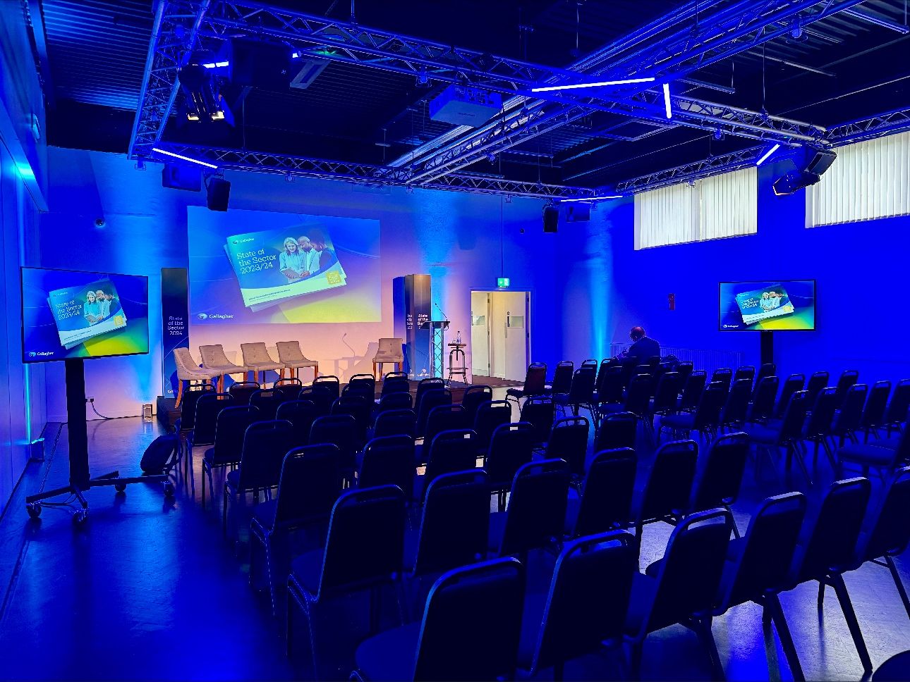 Event space at Queenhithe, modern setup with blue lighting for presentations and discussions.