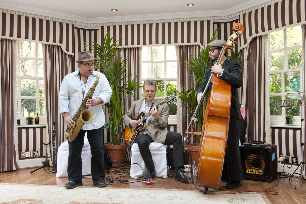 Trio of musicians performing at Beach Bar, elegant venue for networking events.