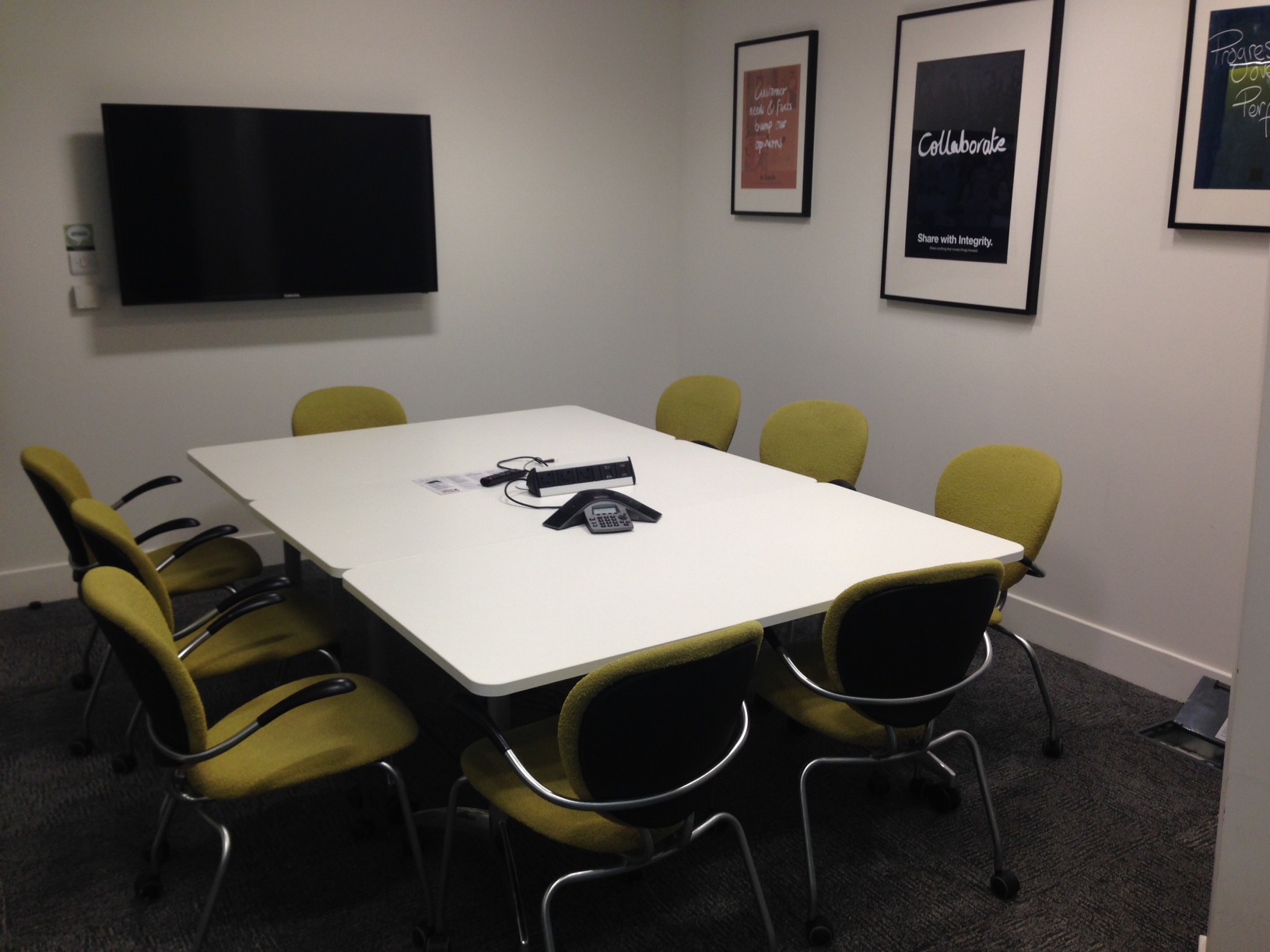 Modern meeting room with large white table, ideal for collaborative discussions and brainstorming.