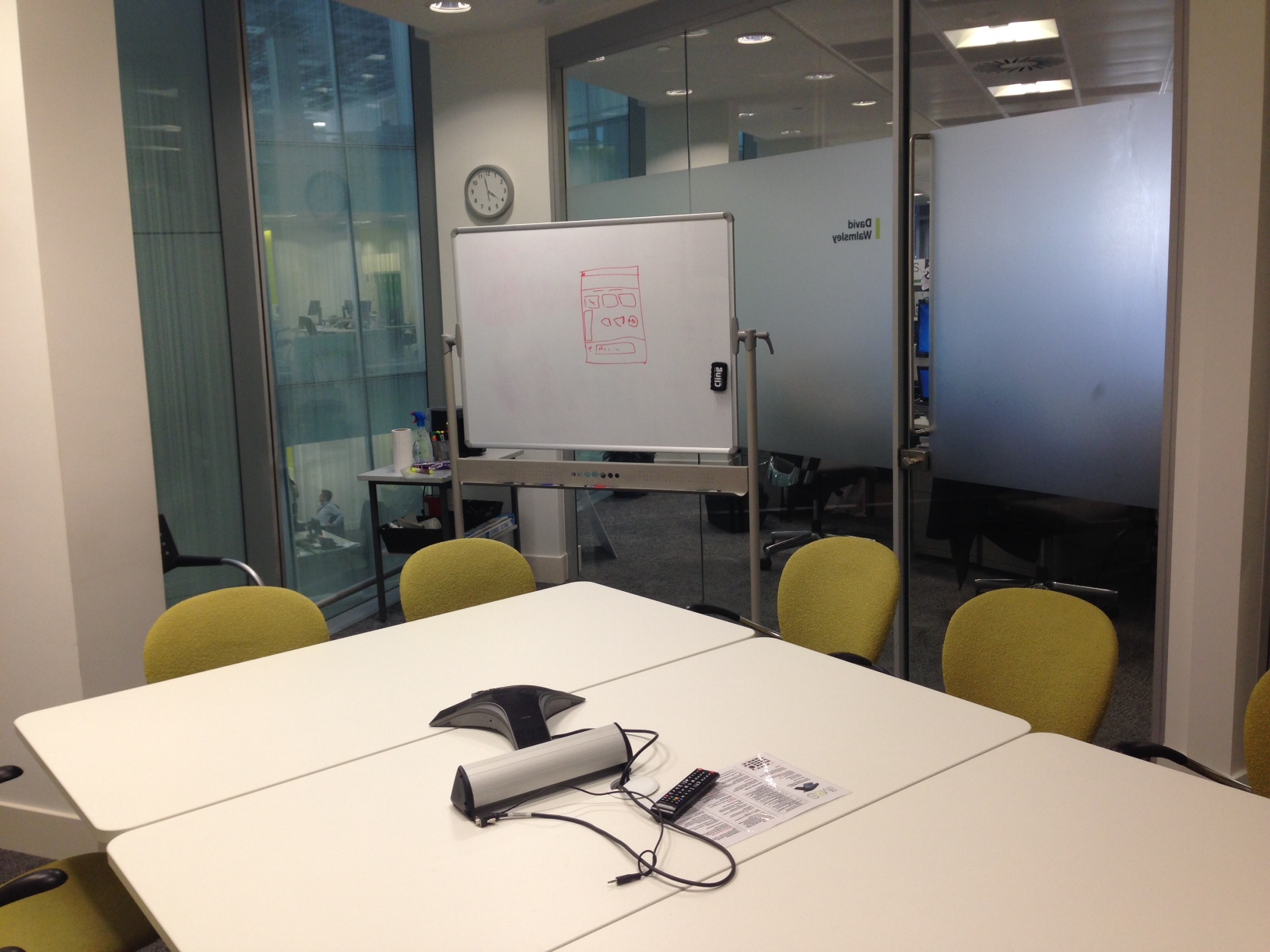 Modern meeting room with circular table and whiteboard for collaborative brainstorming.