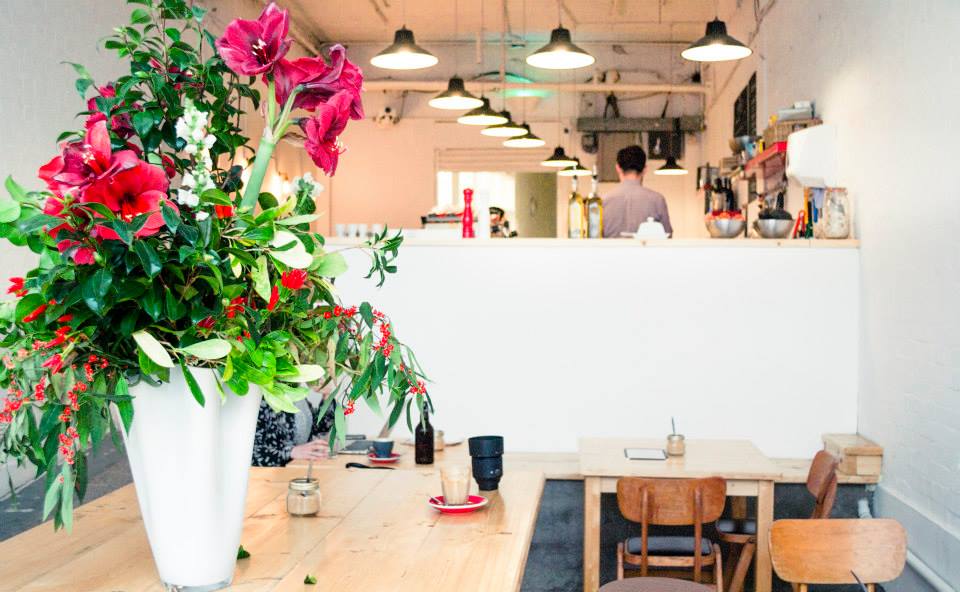 Modern cafe venue with floral centerpiece, perfect for intimate events and meetings.