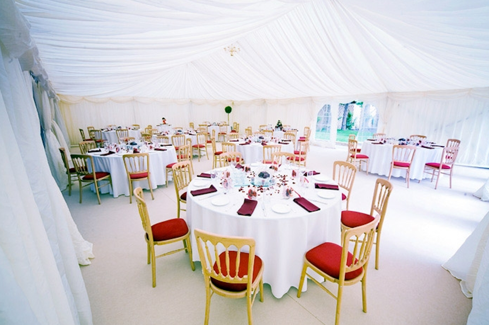 Orchard Suite at The Limes Lodge, elegant event space with round tables and red accents.