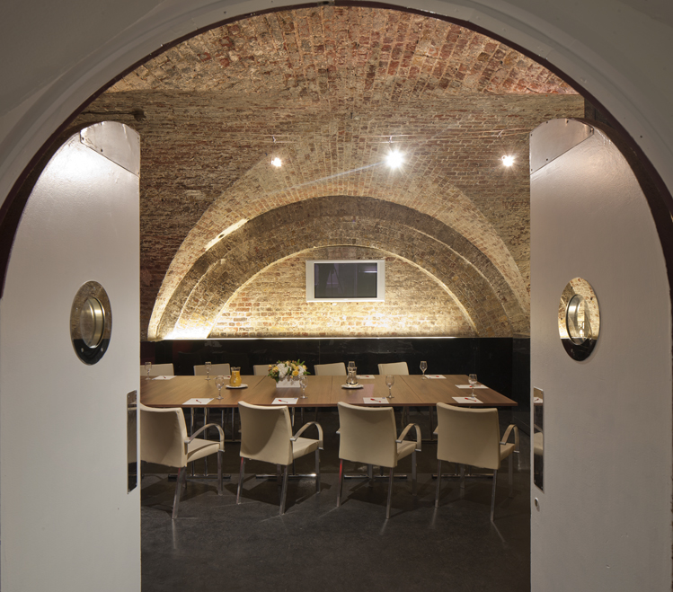 Stylish meeting space with arched brick ceiling, perfect for corporate events and gatherings.