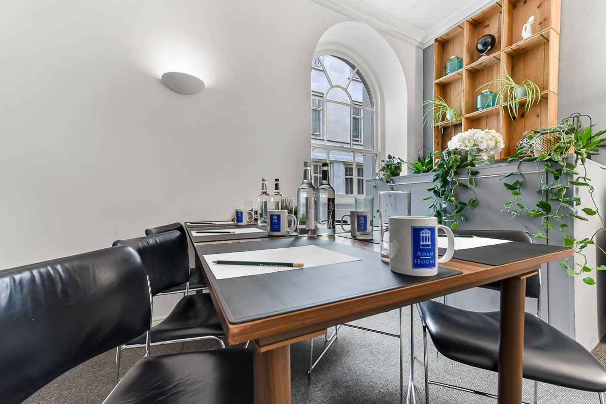 Adam Room meeting space with sleek table, natural light, ideal for brainstorming sessions.