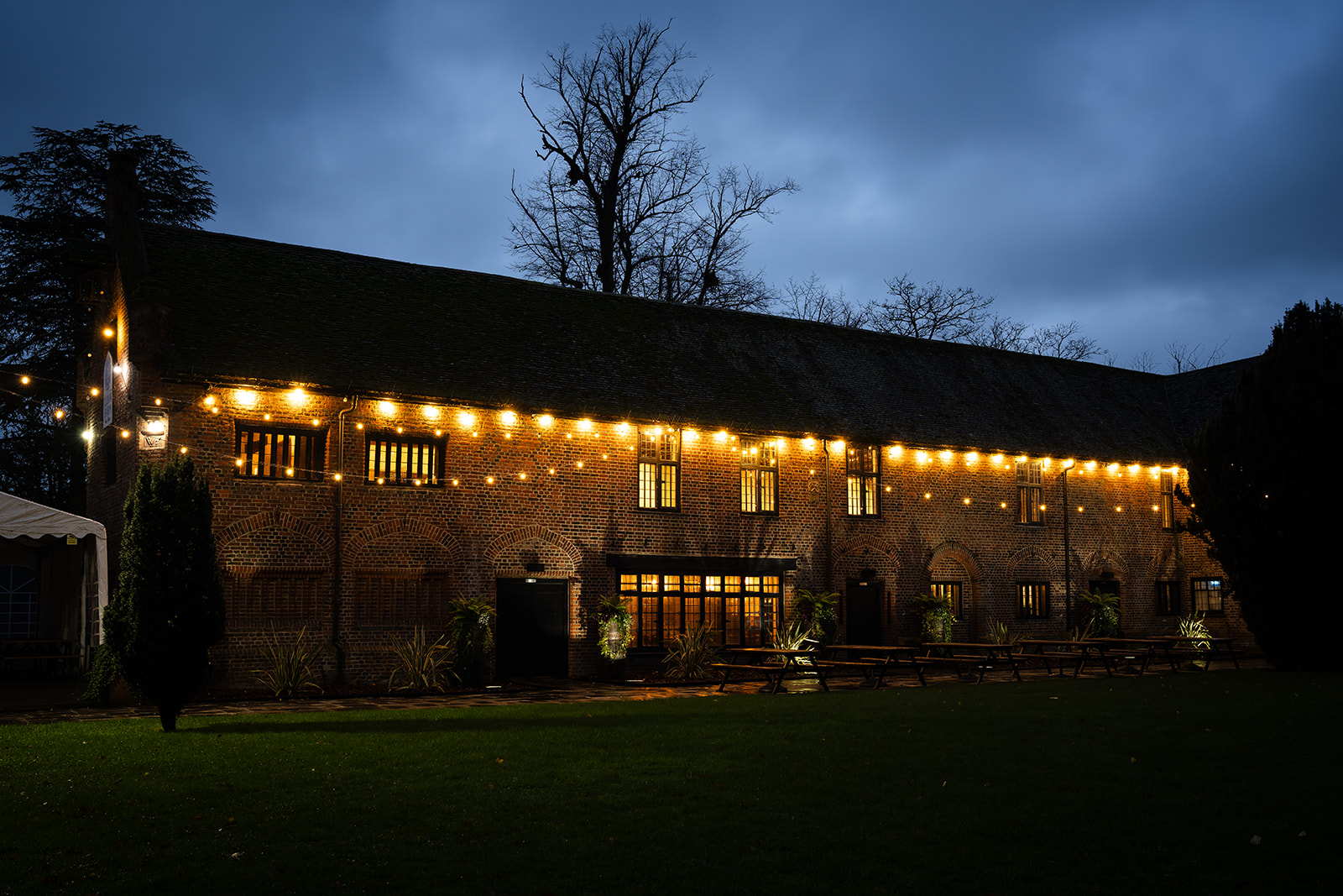 Charming Tudor Barn Eltham venue with string lights, ideal for weddings and events.