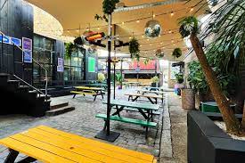 Vibrant outdoor event space at 93 Feet East with colorful picnic tables for gatherings.