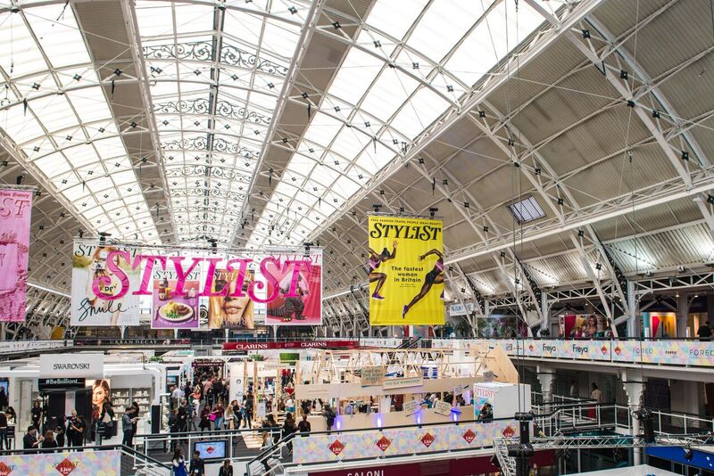 Mezzanine exhibition space at Business Design Centre, bustling with attendees and vibrant displays.