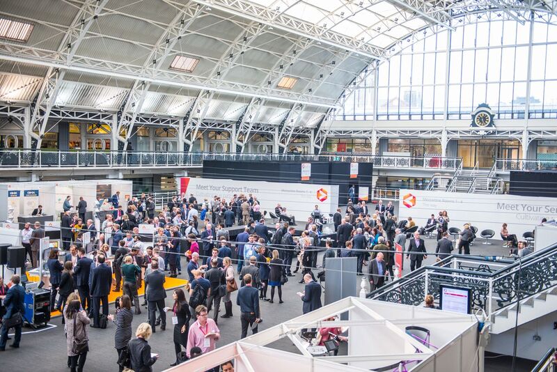 Mezzanine exhibition hall bustling with attendees networking at Business Design Centre.