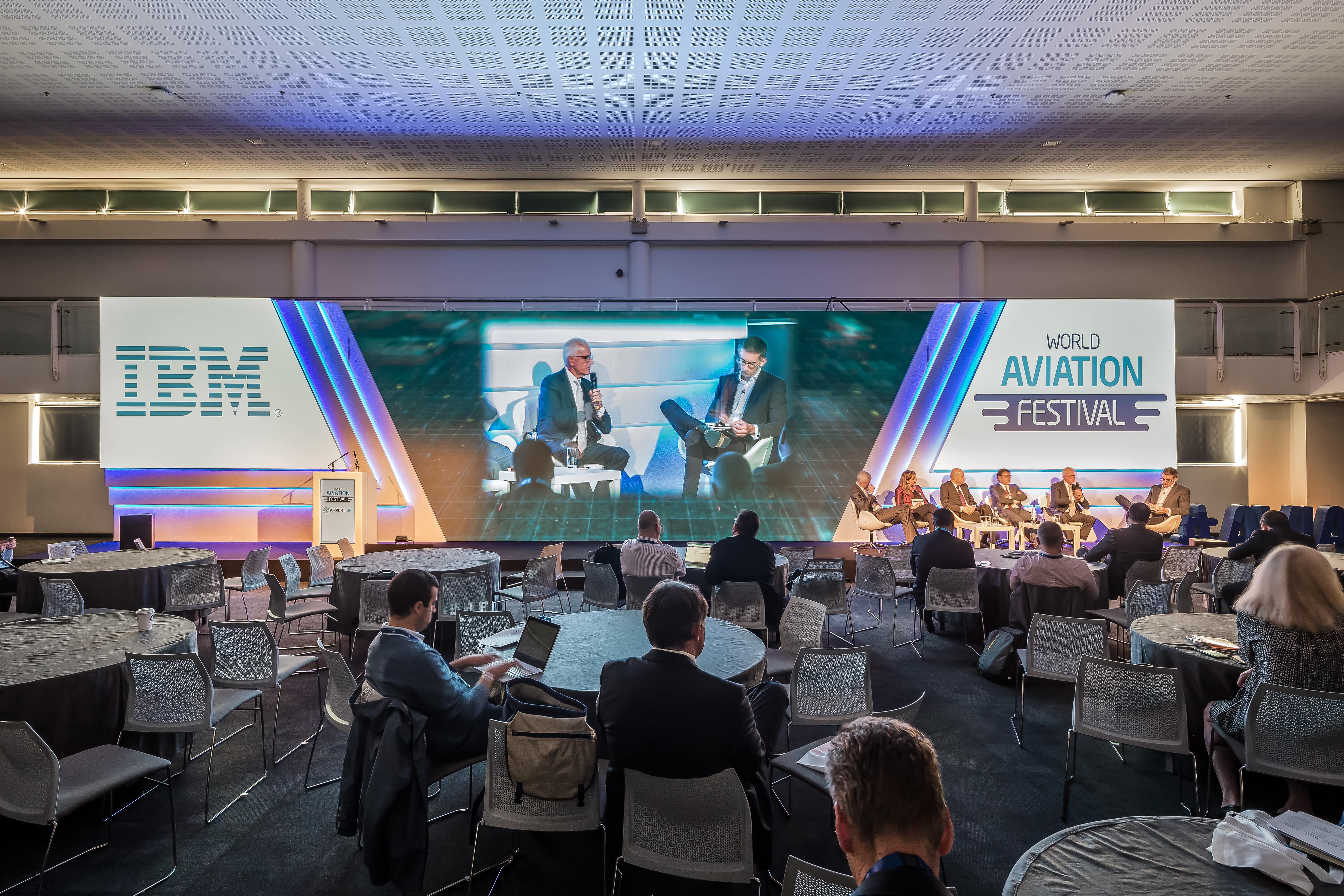 Conference panel discussion in Business Design Centre's Gallery Hall, featuring IBM branding.