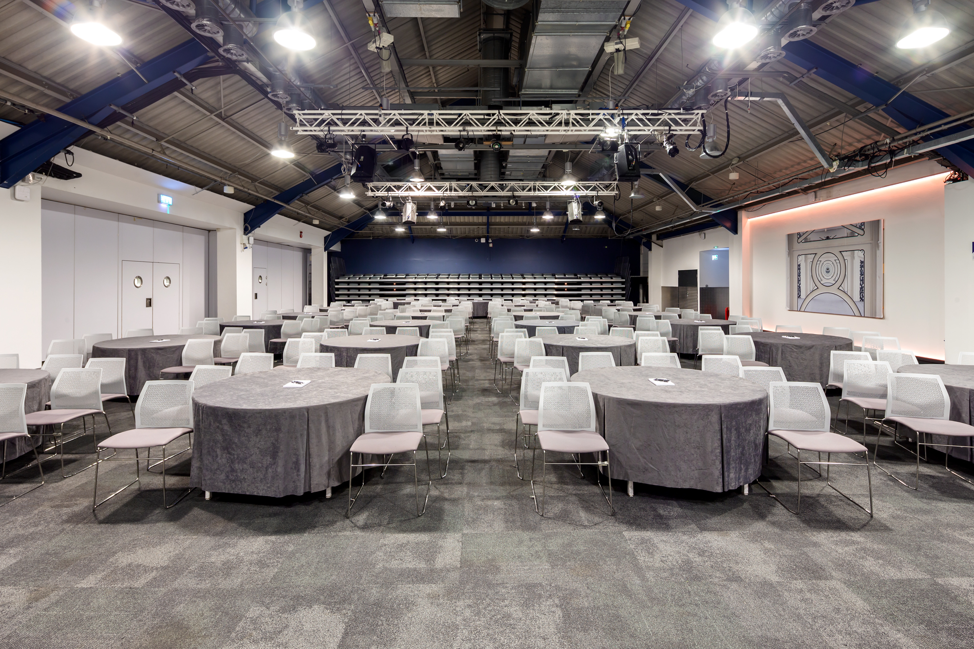 Versatile auditorium with round tables, ideal for conferences and workshops.
