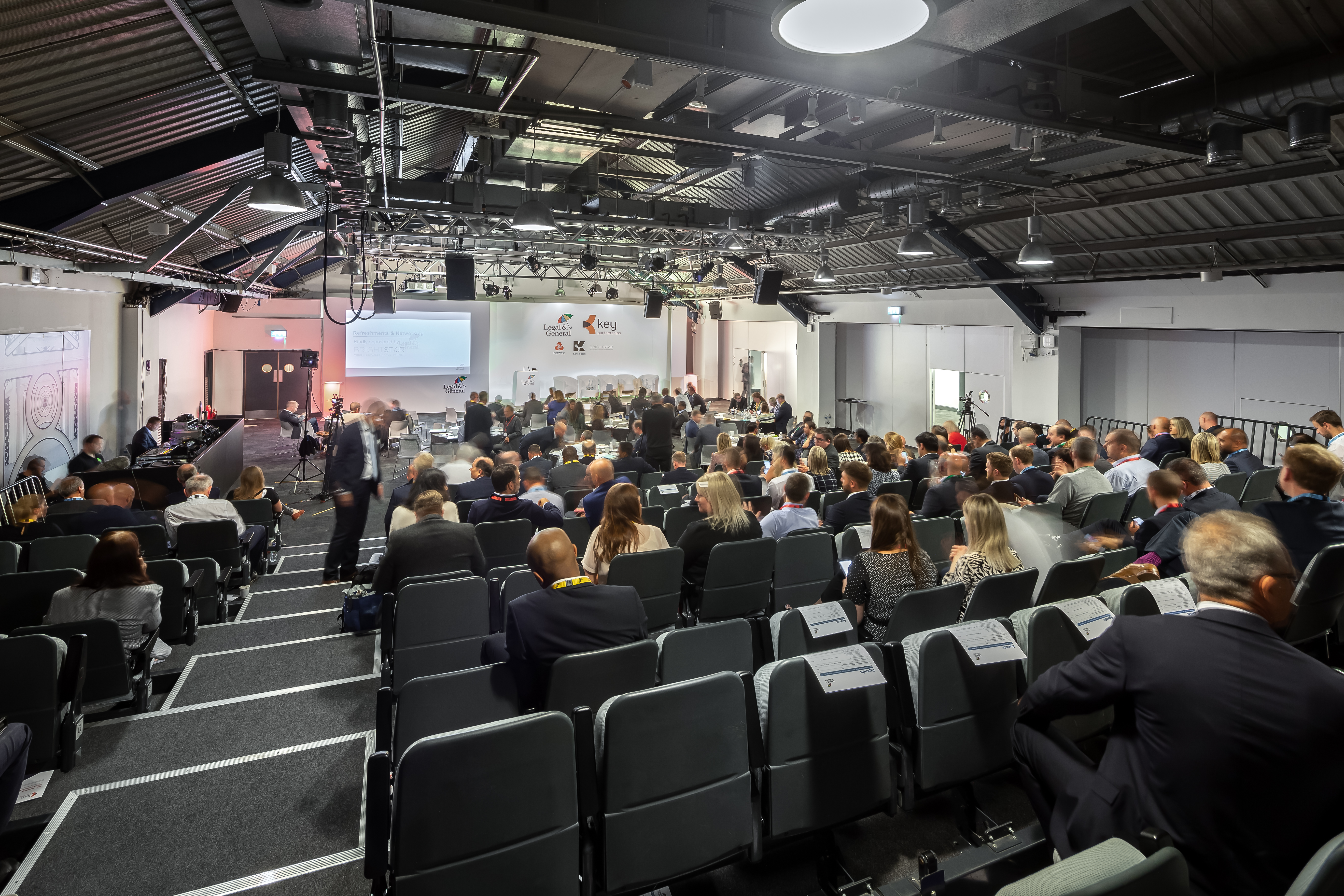 Auditorium at Business Design Centre during a conference with tiered seating and networking.