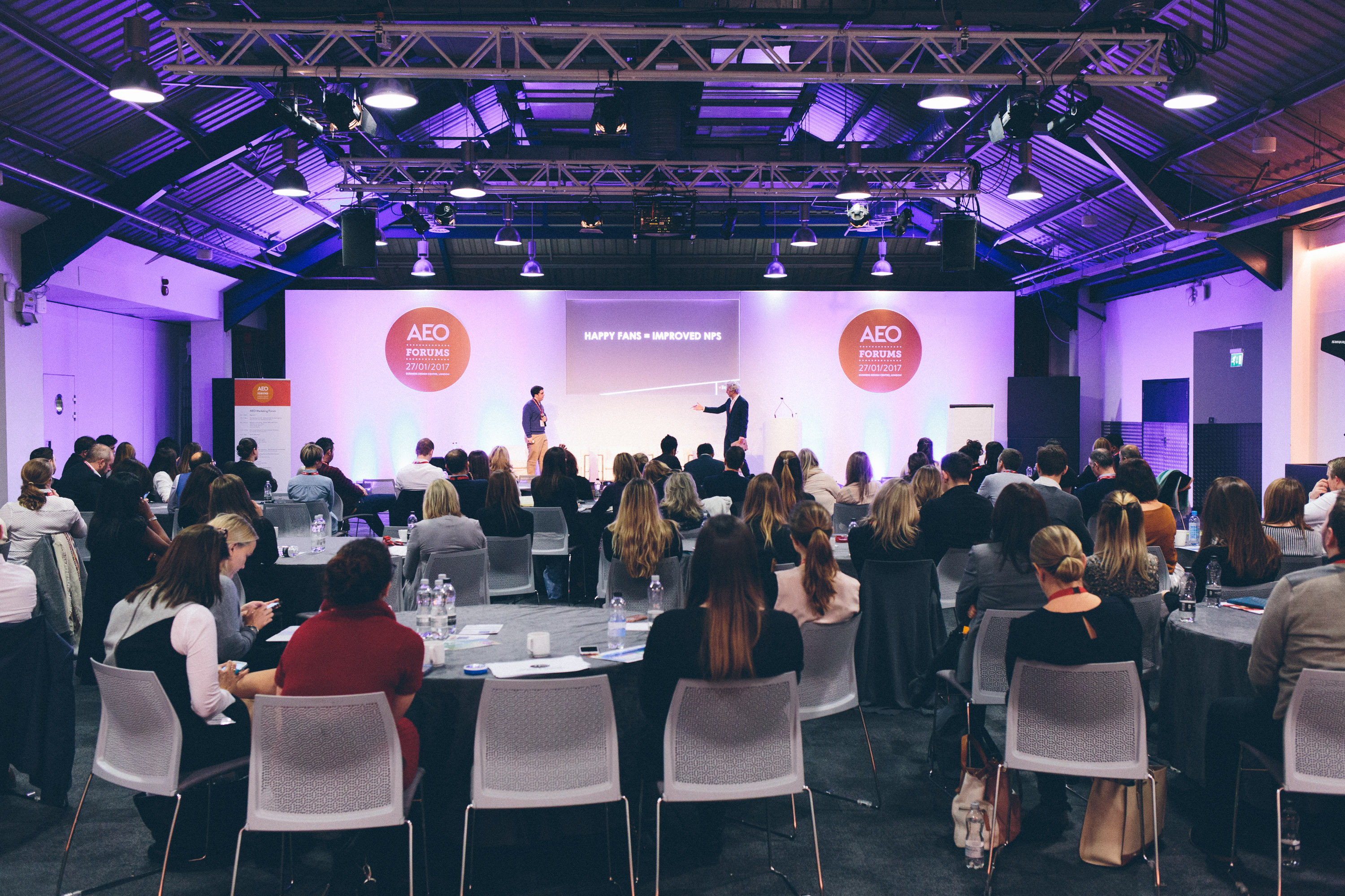 "Conference in Business Design Centre with speaker engaging audience at modern venue"