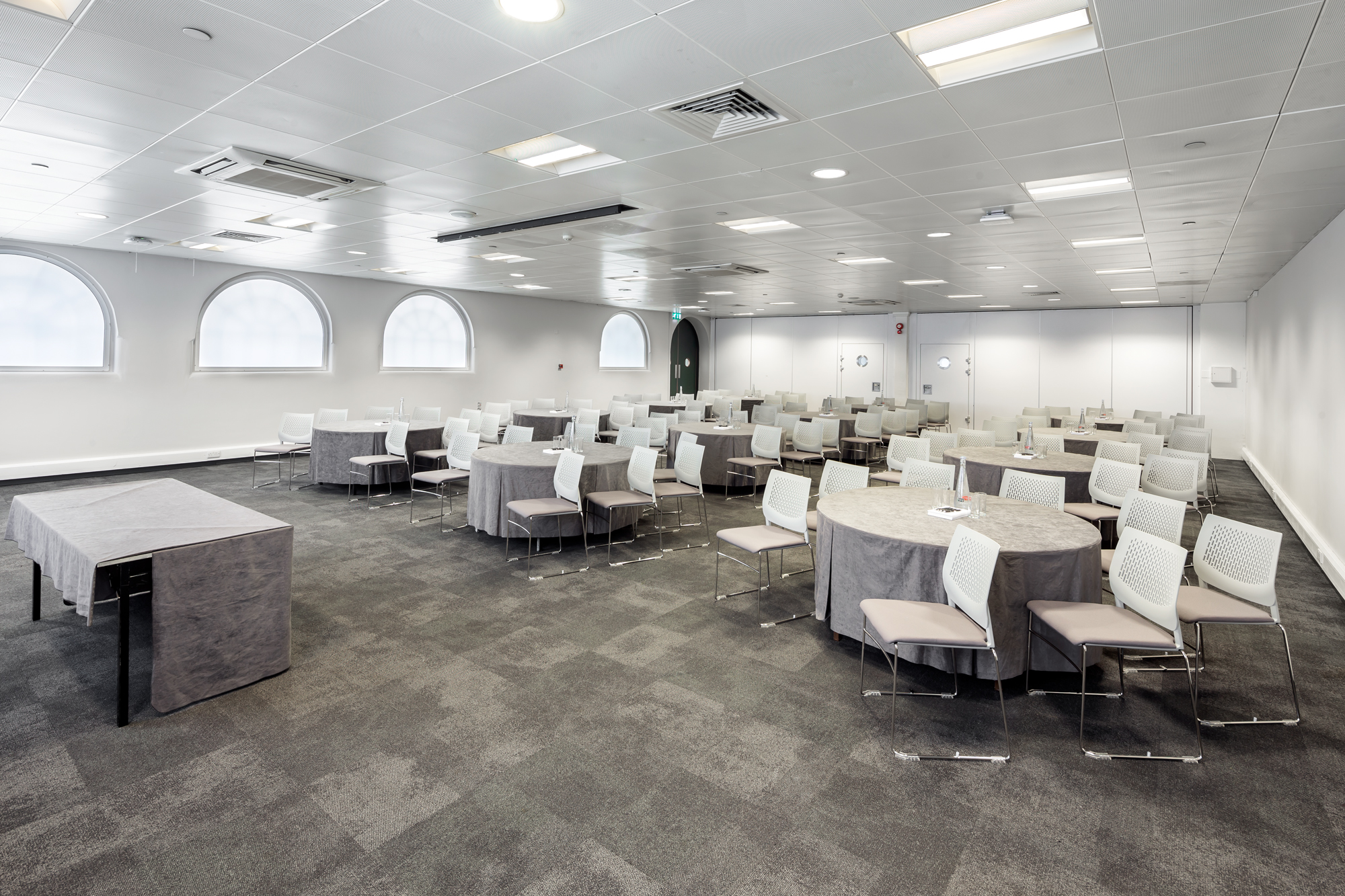 Versatile event space with round tables in Business Design Centre for networking sessions.