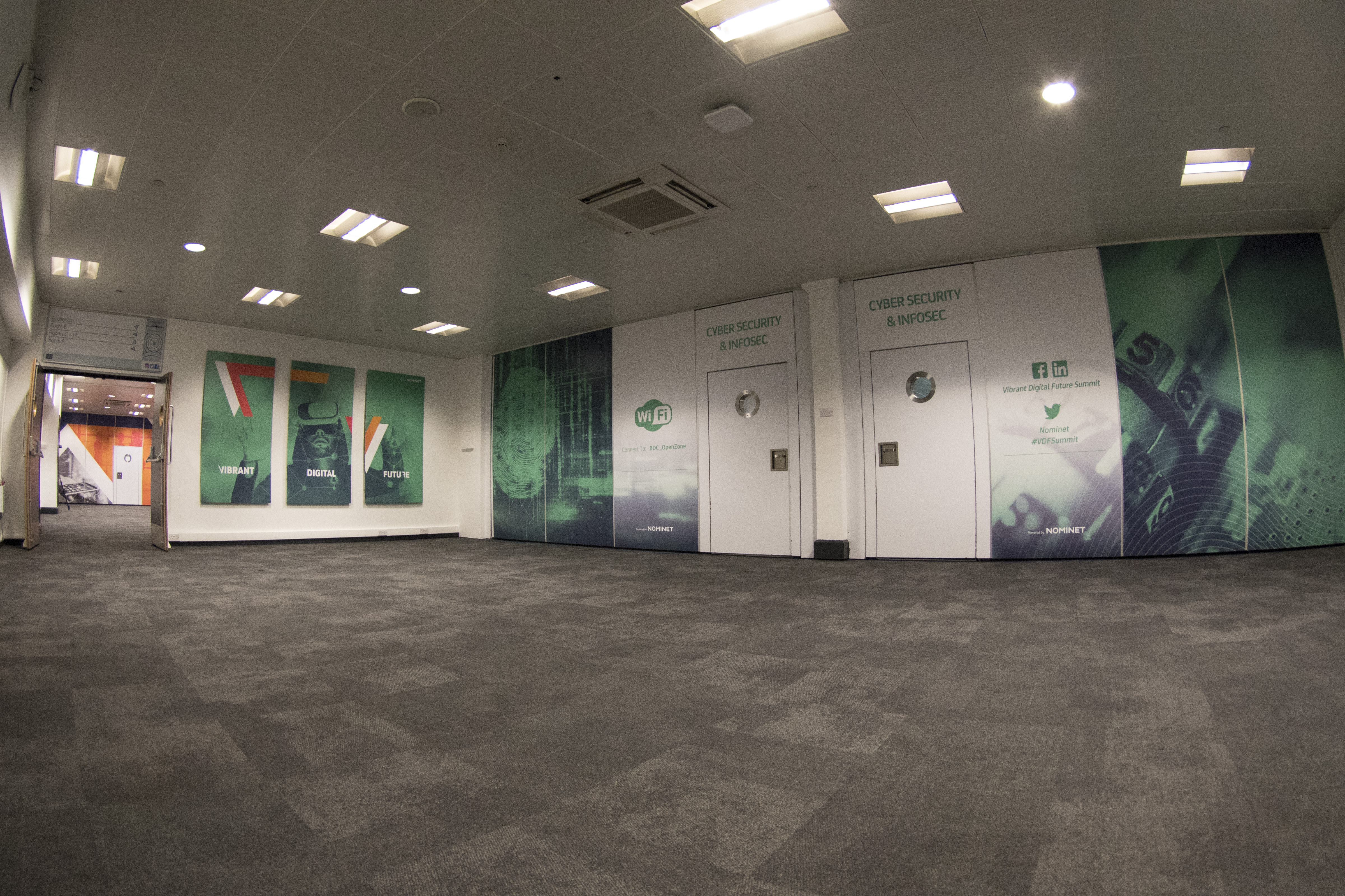 Spacious event space with branded wall graphics for corporate meetings and conferences.