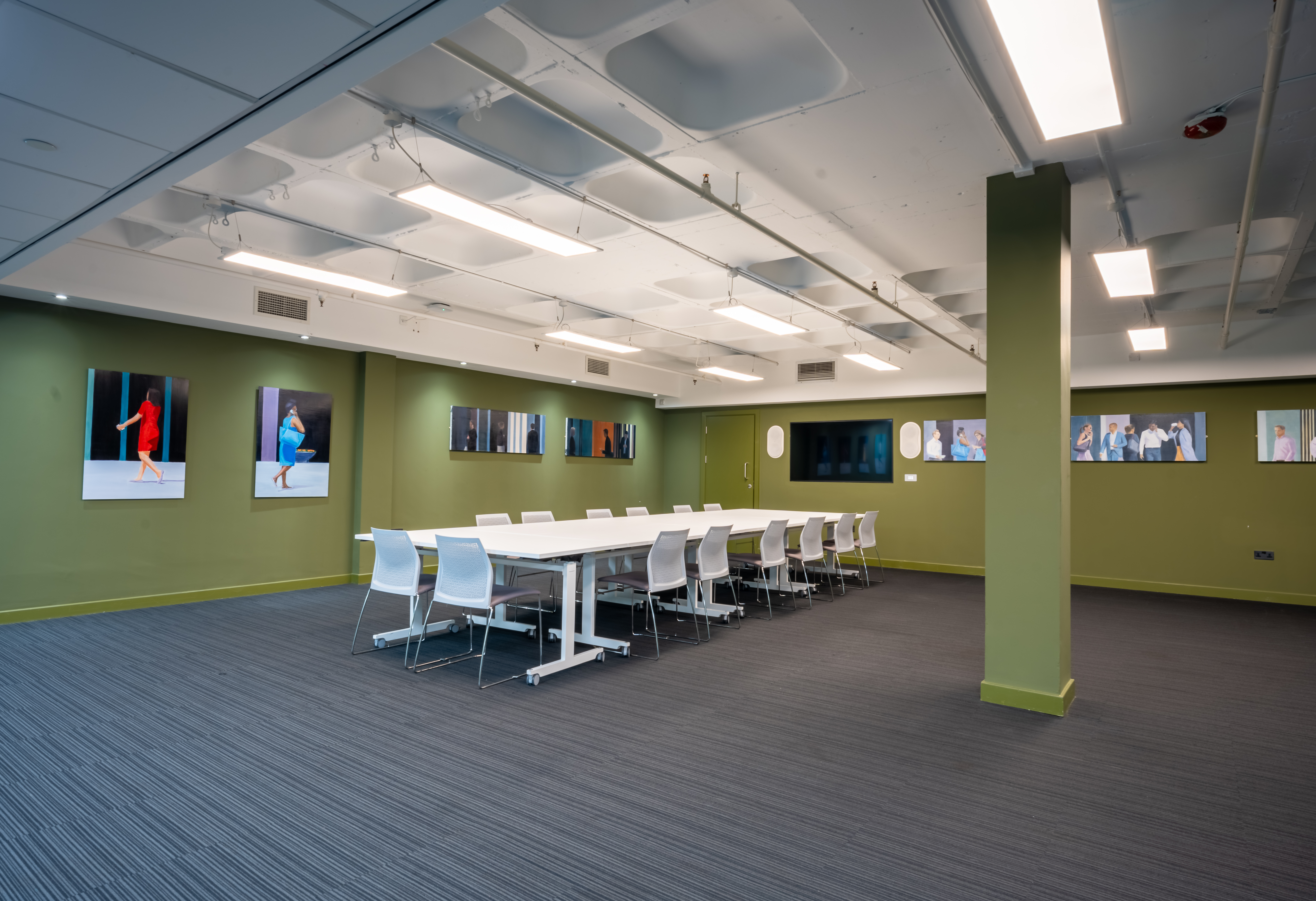 Modern meeting room with conference table, green walls for business workshops.