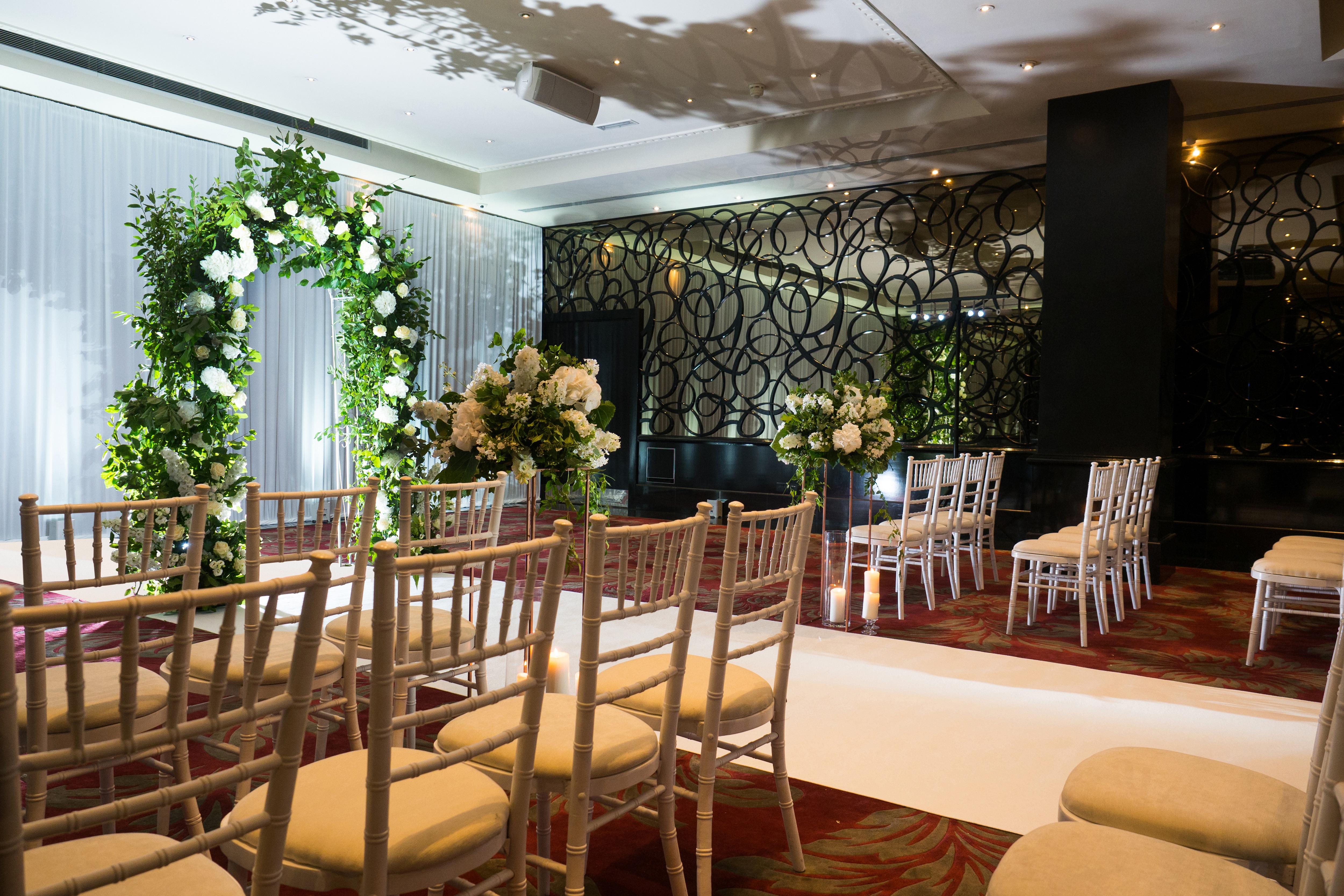 Elegant wedding venue with floral arch and soft lighting at The Danziger, May Fair Hotel.