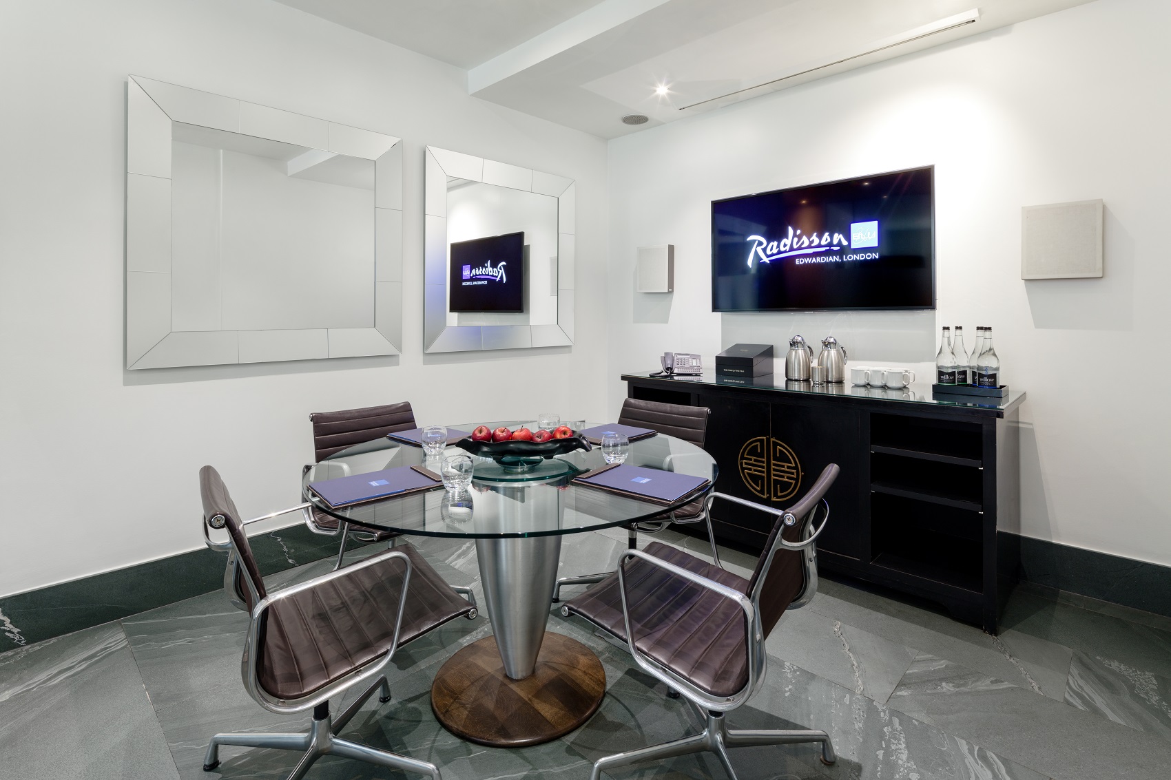 Modern meeting room with glass table, ideal for corporate events and presentations.