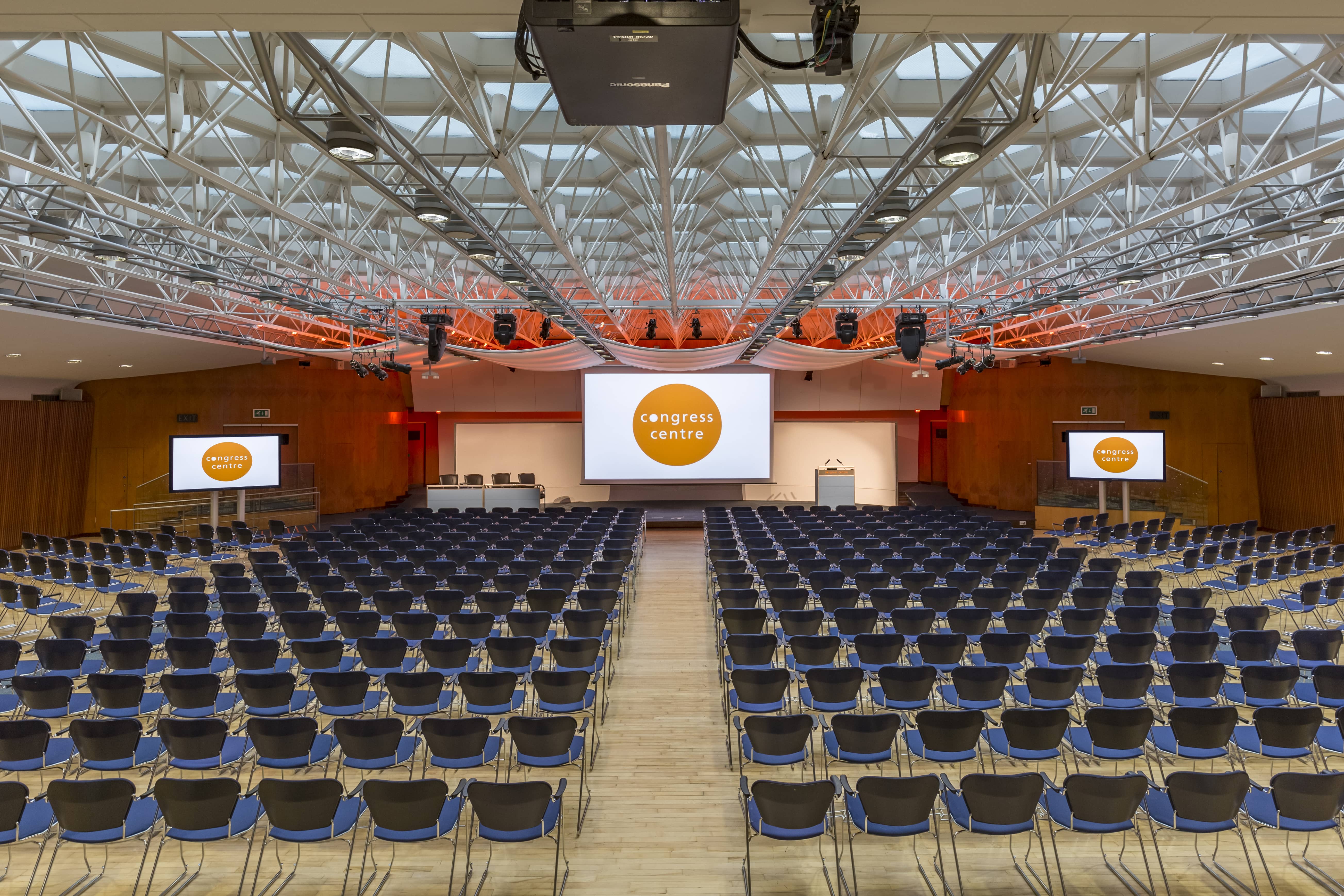 Spacious Congress Hall set for a conference with arranged chairs and screens.
