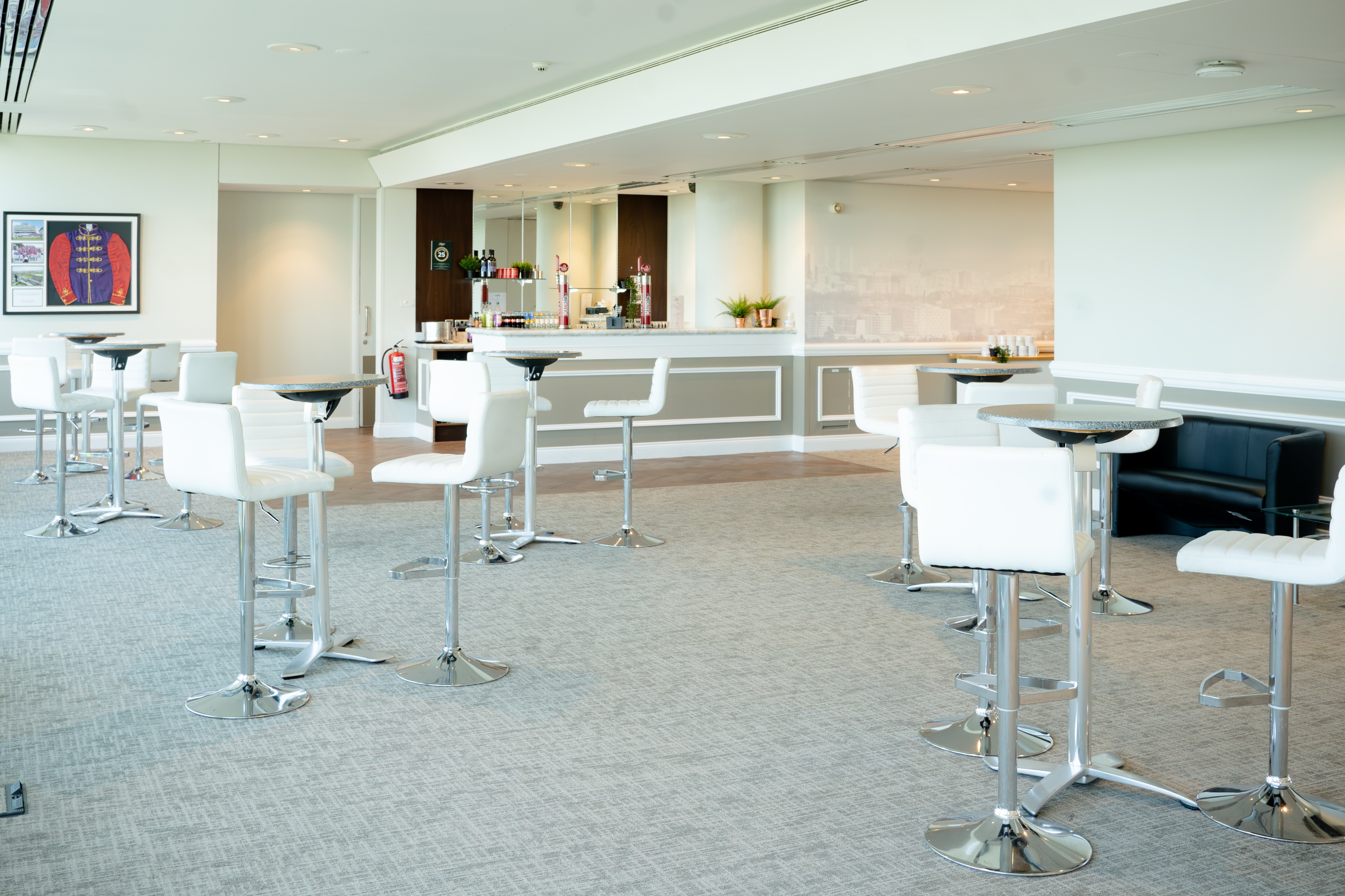 Modern event space at Epsom Downs Racecourse with high-top tables for gatherings.