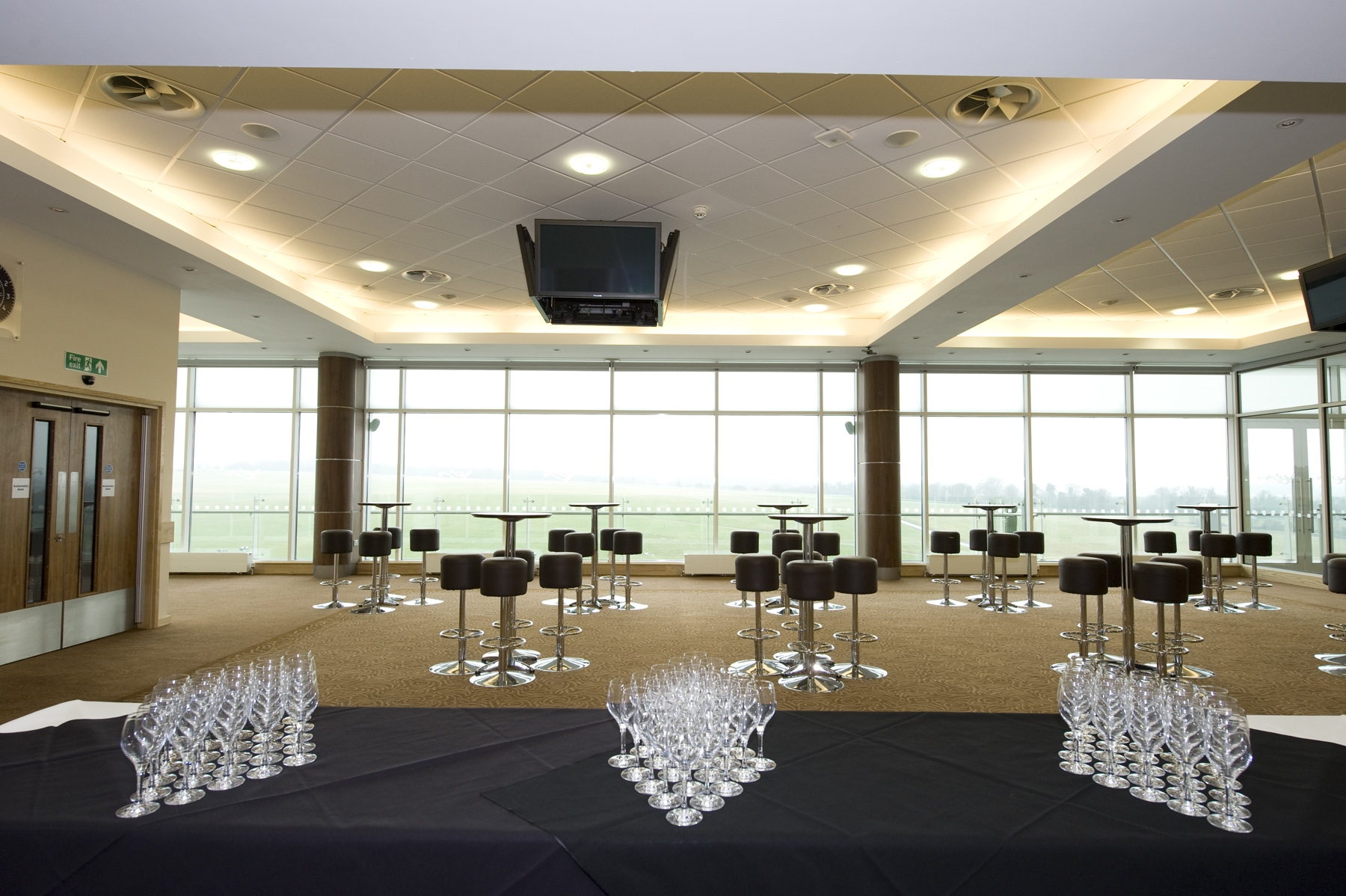 Modern event space at Epsom Downs Racecourse with floor-to-ceiling windows for receptions.