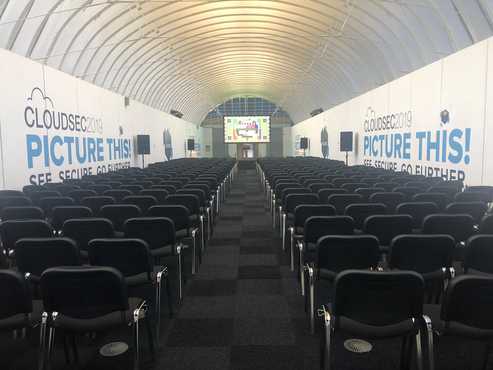Spacious conference hall with black chairs for tech event at The Gallery, Old Billingsgate.